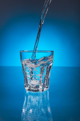 pouring raw clear water into a glass beaker