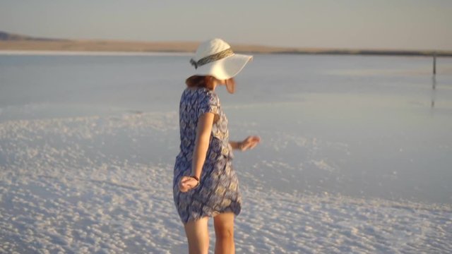 happy smiling girl enjoying a sunset, dancing and laughs on expanse of salt lake