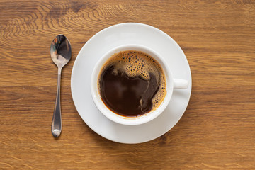 coffee in white cup on wood table, top view