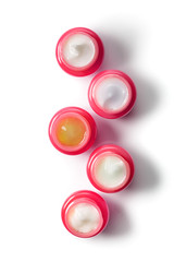 Set of five red jars with moisturizers for the face in a row, top view. The concept of natural cosmetics.