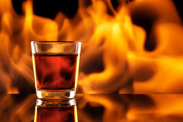 whiskey in small shot glass and fire