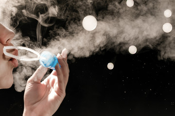 girl blowing bubbles with smoke on a black background