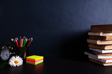 books with an alarm clock on desktop
