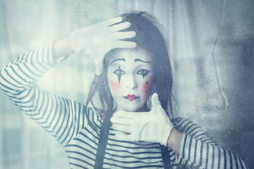 mime through a wet window. Creative portrait