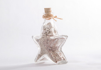 Glass bottle in the shape of a star with sand from beach