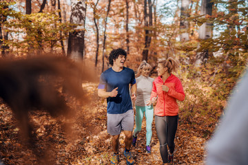 Small group of people running in woods.