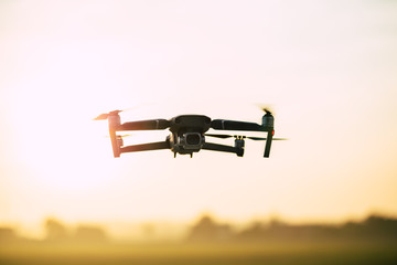 Drone like Mavic 2 Pro flying during sunset.