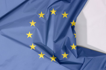 European Union fabric flag crepe and crease with white space, A circle of twelve five-pointed yellow stars on a blue field.