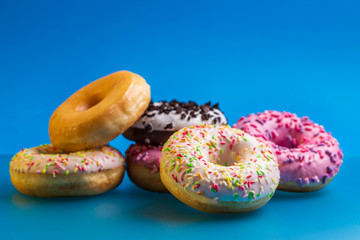 Heap of colorful donuts on blue background.
