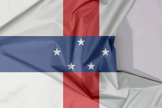 Netherlands Antilles fabric flag crepe and crease with white space, A circle of twelve five-pointed yellow stars on a blue field.