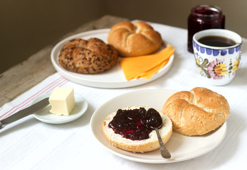 Breakfast with Kaiser rolls, currant jam, butter and cheese and tea.