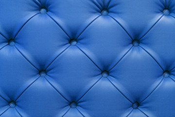 Fototapeta na wymiar Background of leather blue sofa, stitched buttons.