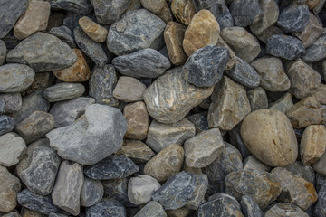 a lot of large multi-colored  gravel stones. blue, white and gray stones in one pile