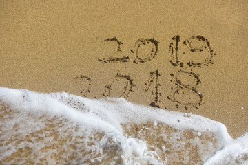 Fototapeta premium New Year 2019 concept. The inscription on the sand a number message Year 2018 replace 2019