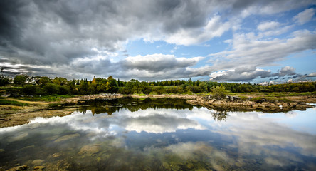 Sandy hills. Lake in the Sandy canyon. Warm colors background. Yellow sandstone textured mountain, white thin sand dune, bright sky. Sunshine landscape