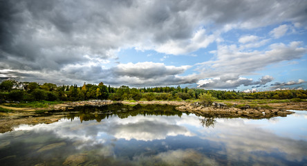 Sandy hills. Lake in the Sandy canyon. Warm colors background. Yellow sandstone textured mountain, white thin sand dune, bright sky. Sunshine landscape
