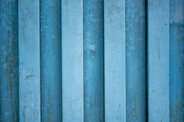 white blue metal wall. vertical lines. paint and rust stains