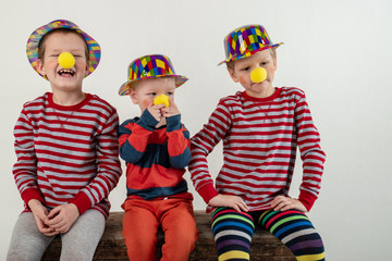 Funny clown children dressed up in costumes and represent the circus. The child is playing at home....