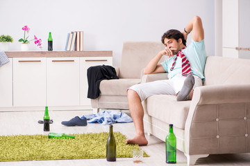 Obraz premium Young drunk handsome man after party at home 