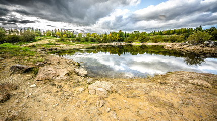 Sandy hills. Lake in the Sandy canyon. Warm colors background. Yellow sandstone textured mountain, white thin sand dune, bright sky. Sunshine landscape