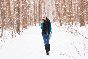 Fototapeta na wymiar Happy young woman walking in winter time. Pretty girl in snowy nature