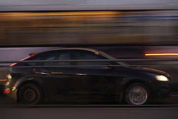 Plakat car blurred in motion, black. with city lights. long exposure