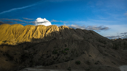Sandy hills. Sandy canyon. Warm colors background. Yellow sandstone textured mountain, white thin sand dune, bright sky