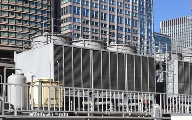 Cooling tower for HVAC system with coils and fins on display with backdrop on city buildings