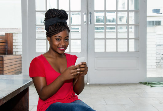 Attractive african american woman sending message with phone