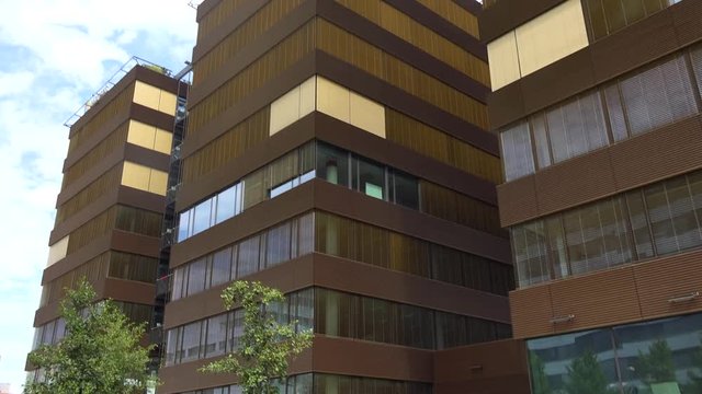 A brown office building in an urban area on a sunny day - view from below