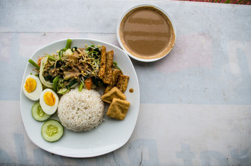 GADO GADO typical Indonesian salad with hard-boiled eggs, boiled potato, fried tofu and tempeh and peanut sauce - copy space on the right side.