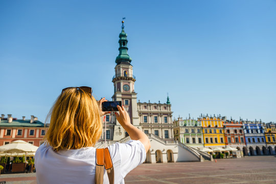 Woman photographing Old Town of Zamosc, Poland