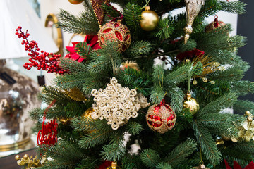 Christmas tree with many red and golden decorations, closeup, letters, merry christmas, interior details