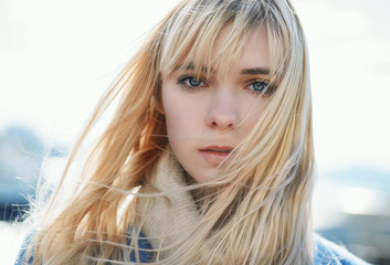 Portrait of young woman wearing blue coat.