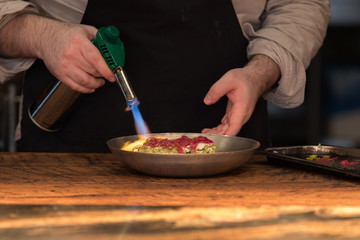 Chef preparing food with fire burner