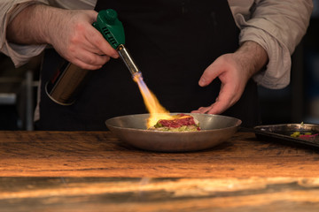 Chef preparing food with fire burner
