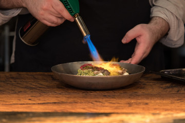 Chef preparing food with fire burner