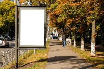 empty white citylight near the pedestrian road. blank vertical billboard on the street during autumn, Blank template. - obrazy, fototapety, plakaty
