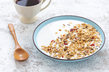 Granola, oatmeal with milk, honey and strawberry on blue plate

