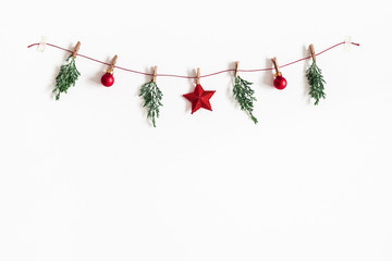Christmas composition. Garland made of red balls and fir tree branches on white background. Christmas, winter, new year concept. Flat lay, top view, copy space - 231318616
