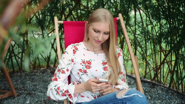Young woman using smartphone in plant gazebo.