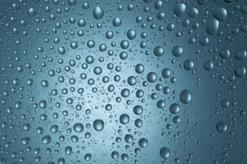Water drops on round blue background, soft focus, close up