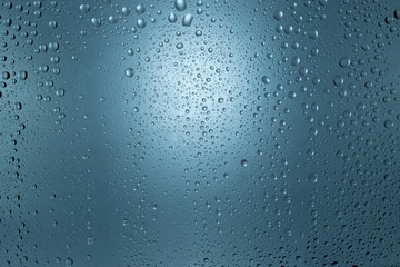 Water drops on round blue background, soft focus, close up