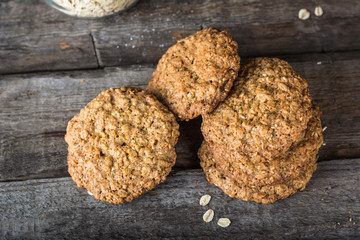 Homemade oatmeal cookies on wooden board on old table background. Healthy Food Snack Concept. Copy space. Milk and cookies. Still life of food. Christmas cookies. Healthy food. Breakfast concept.
