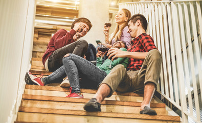 Young trendy friends drinking wine inside trendy hostel