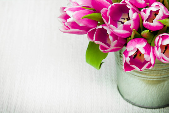 Pink tulip bouquet on light background, copy space