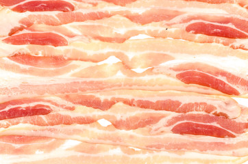 The background of thin strips of smoked bacon lie tightly together.