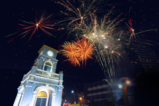Colorful firework celebration..Fireworks displaying up in the sky over clock tower circle landmark of phuket town ..