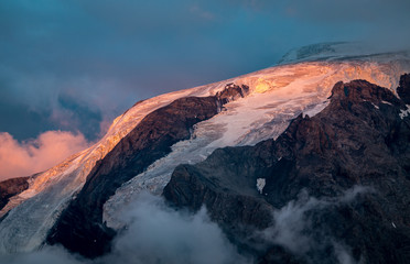 View on Mount Ortler with glacier and clouds at sunset, Passo del Stelvio, Italy.