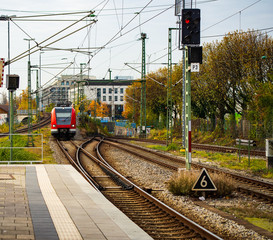 A suburban train arrives in a station above ground